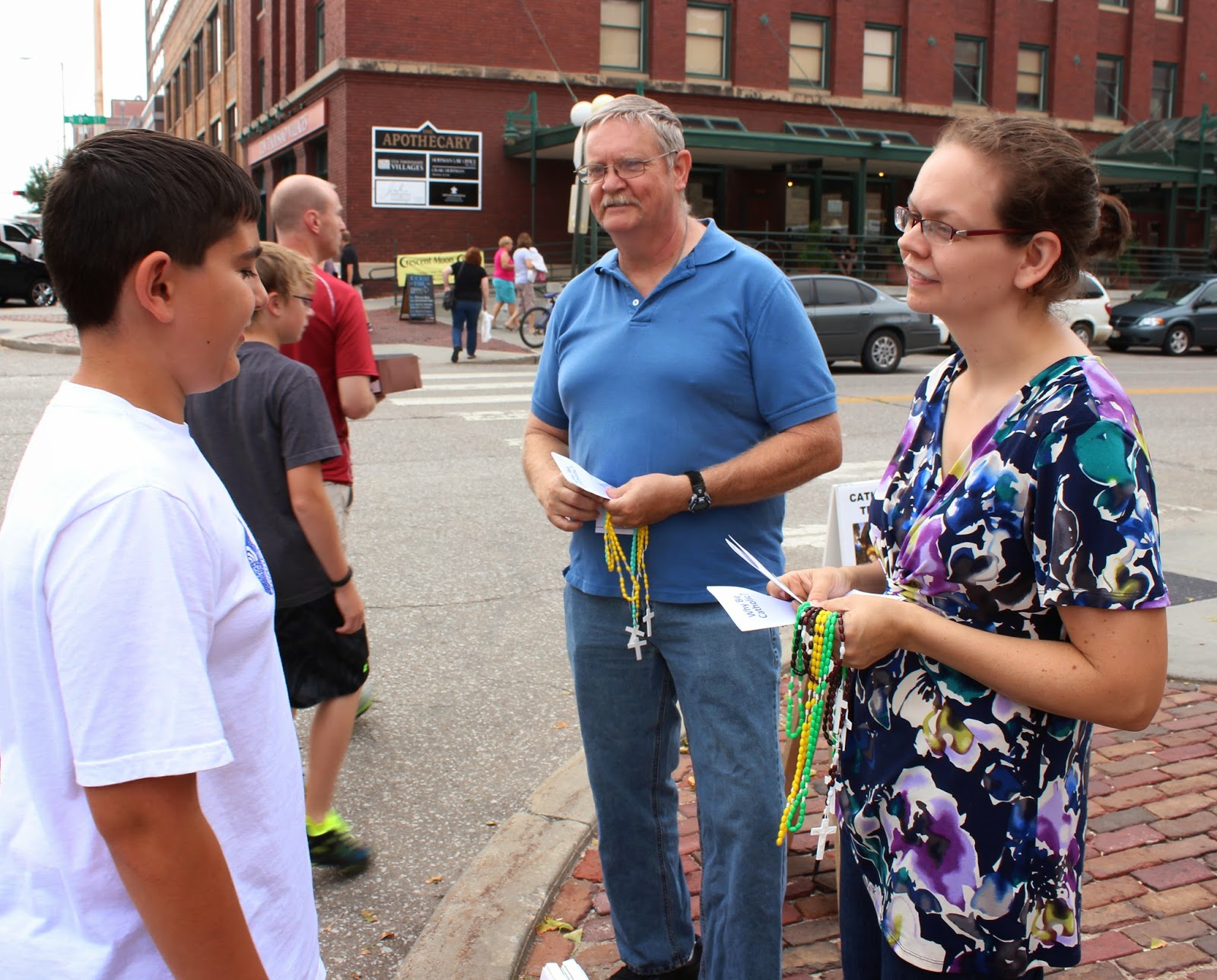 Evangelists offering rosaries and praying with people outdoors